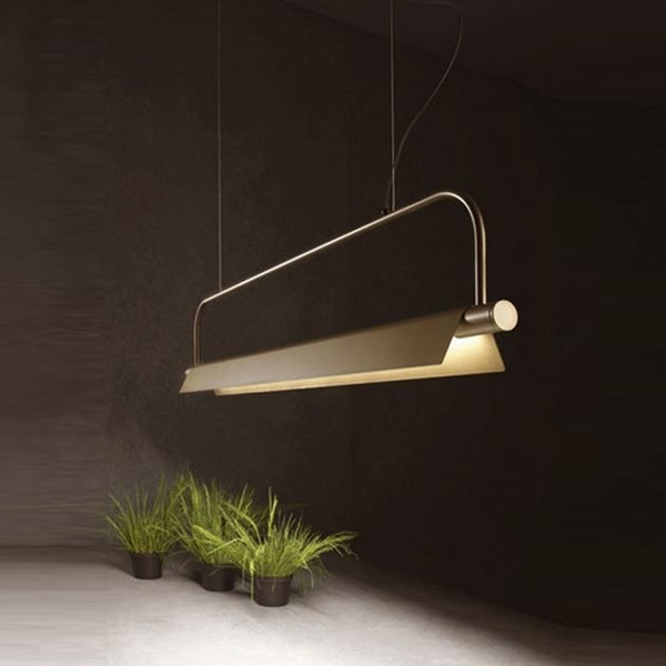 Kramer gold chandelier hanging above a dining table