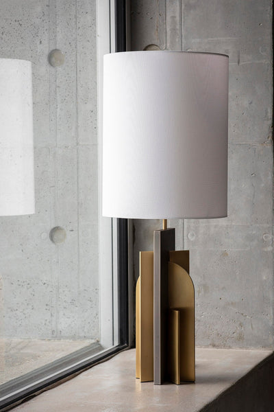 Icon table lamp with brushed brass and grey metal geometric base