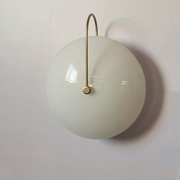 Iris wall light with milky glass shade mounted indoors