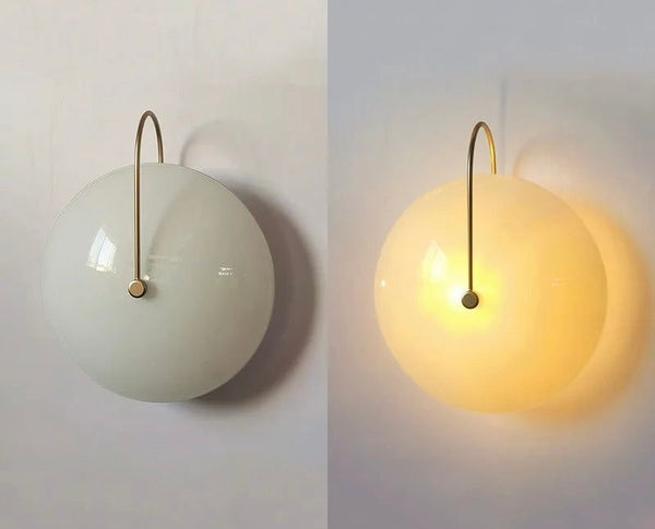 Iris milky glass wall light illuminated with warm light