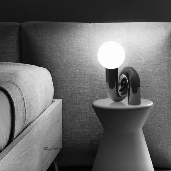 Tubular Neotenic Black Table Lamp with minimalist Nordic design on a Nigerian side table