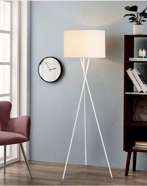 Crossed Nordic Floor Lamp with crossed tripod base in a Nigerian living room