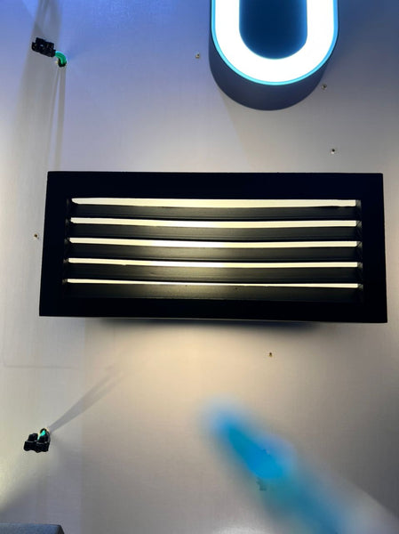 Outdoor wall light mounted on a garden wall in a Nigerian compound