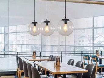 Glass Ball Drop Light with clear spherical glass shade above a dining table