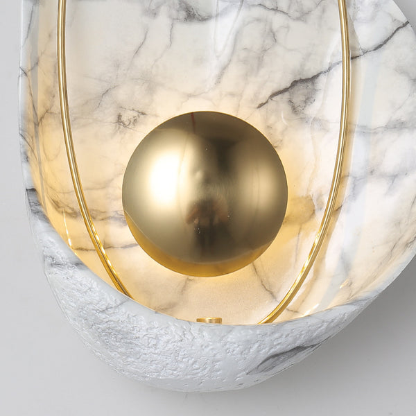 Shell wall sconce close-up showing curved shell design and warm glow